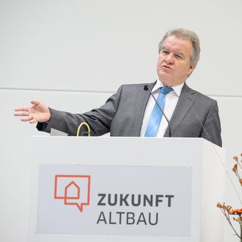 Foto von Landesumweltminister Franz Untersteller am Rednerpult des Herbstforums 2017. Er ist in der Halbtotalen abgelichtet. 