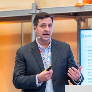 Das Foto zeigt Darius Heller, Doktorand am Institut für Baubetriebslehre, Universität Stuttgart, bei seinem Vortrag auf dem Herbstforum Altbau 2025