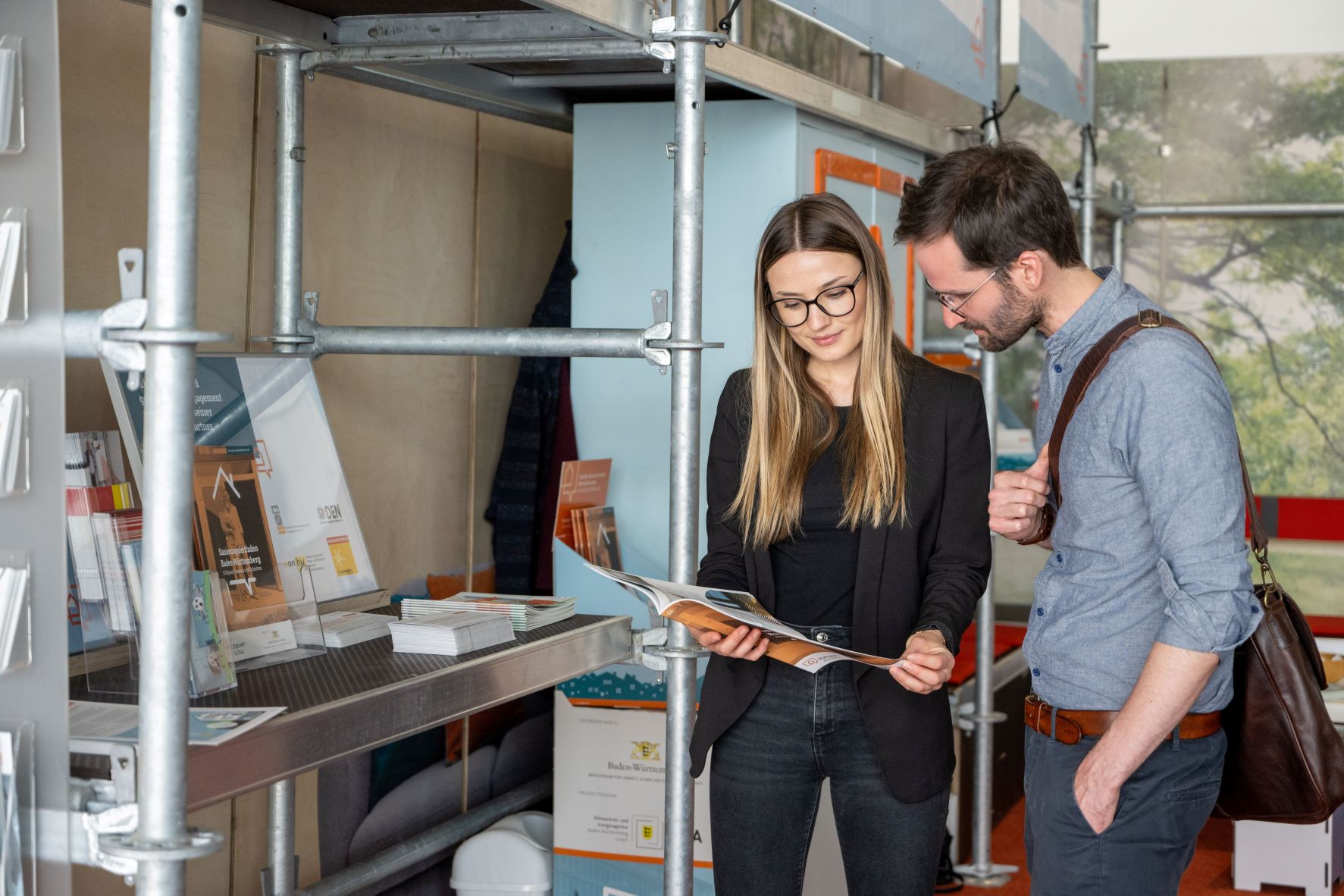Foto eines Paares vor einem Informationsstand von Zukunft Altbau. Die Frau hält eine Infobroschüre in der Hand.